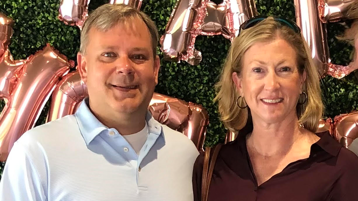 Jeffrey Towers, left, poses in front of a green leaf wall and pink balloons in an undated family photo.