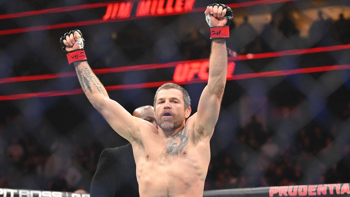 Jim Miller wearing red gloves reacting during fight against Jared Gordon wearing blue gloves