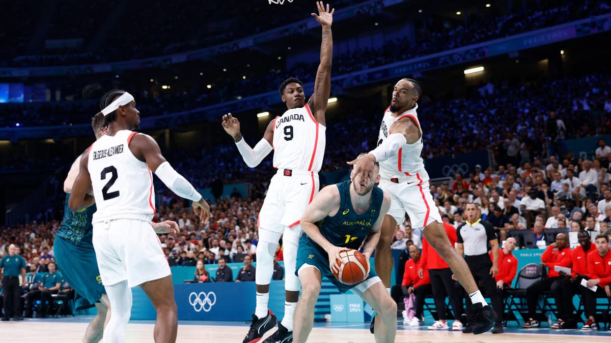 Australia's Jock Landale and Canada's Dillon Brooks competing for the basketball in a game.