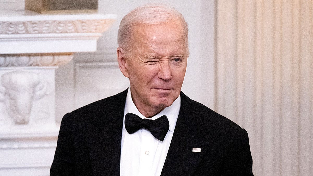 President Joe Biden winking while hosting governors and spouses in the White House dining room