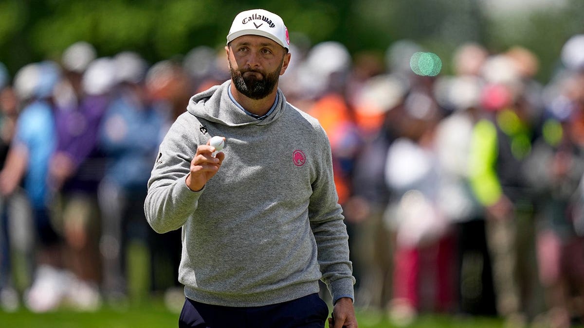 Jon Rahm zwaait na zijn putt op de zesde hole van Aronimink Golf Club