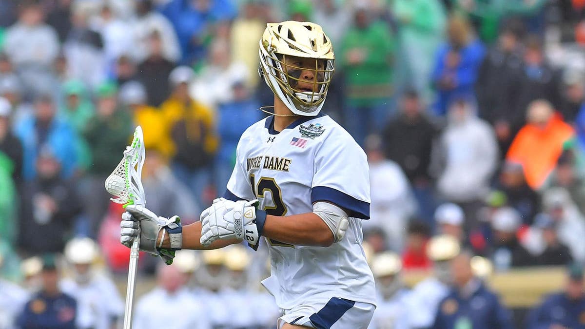Josh Yago of Notre Dame Fighting Irish dodging Vincent Bolognino of Syracuse University Orange during lacrosse game