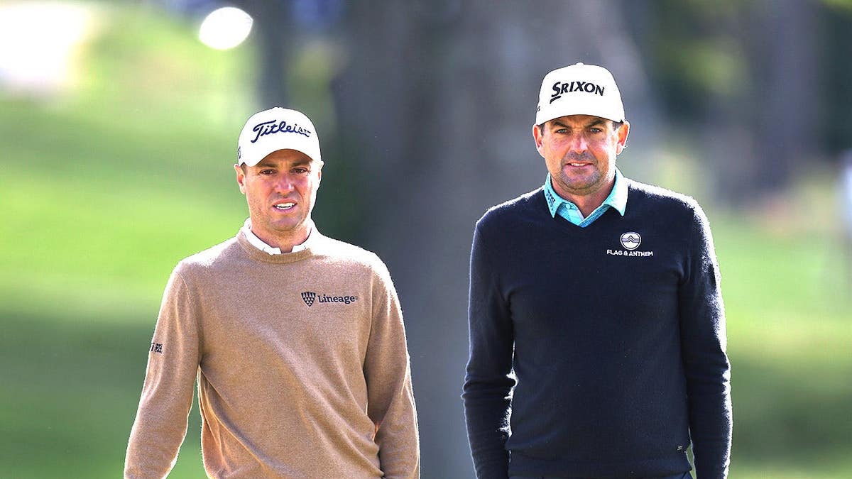 Justin Thomas and Keegan Bradley standing on the tenth green at Aronimink Golf Club