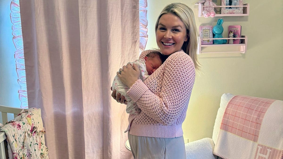 Karoline Leavitt smiling as she cradles newborn baby daughter, Viviana