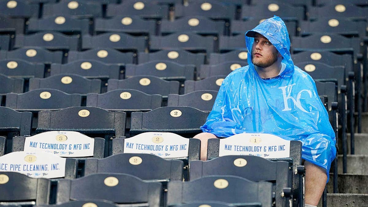 A fan waiting through a rain delay at Kauffman Stadium in Kansas City, Missouri