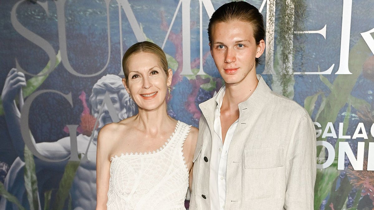 Kelly Rutherford standing with her son Hermes at an outdoor event in Saint-Tropez