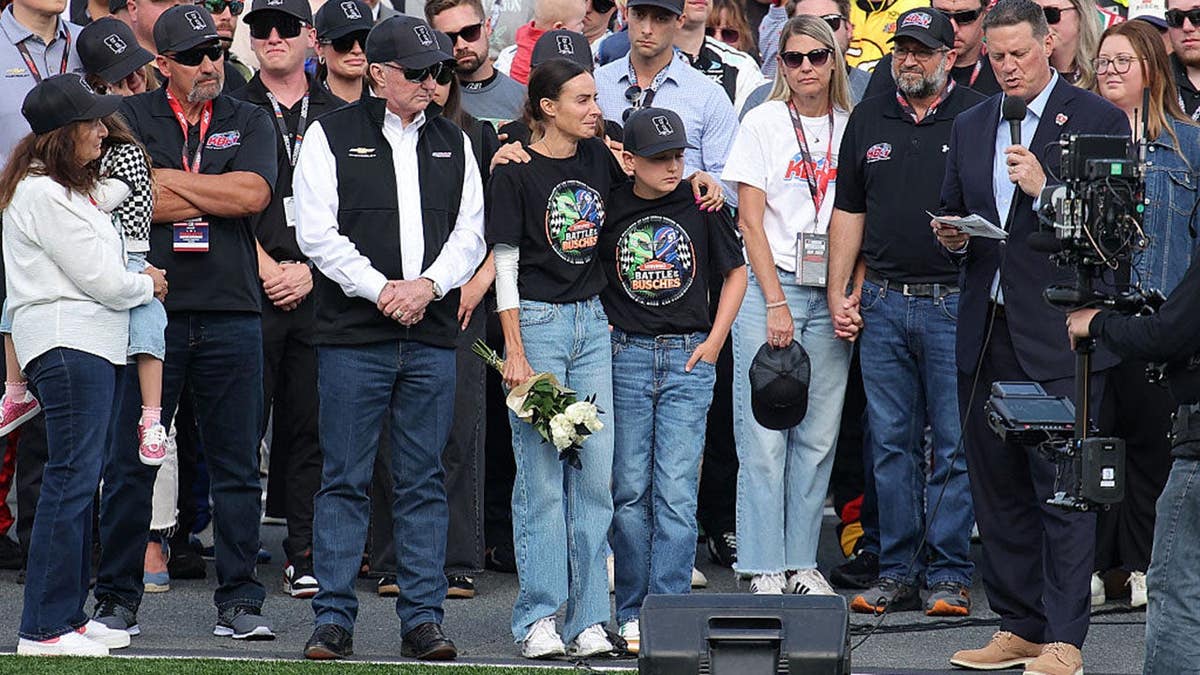 Richard Childress, Samantha Busch, Brexton Busch, and Steve O’Donnell standing on NASCAR grid