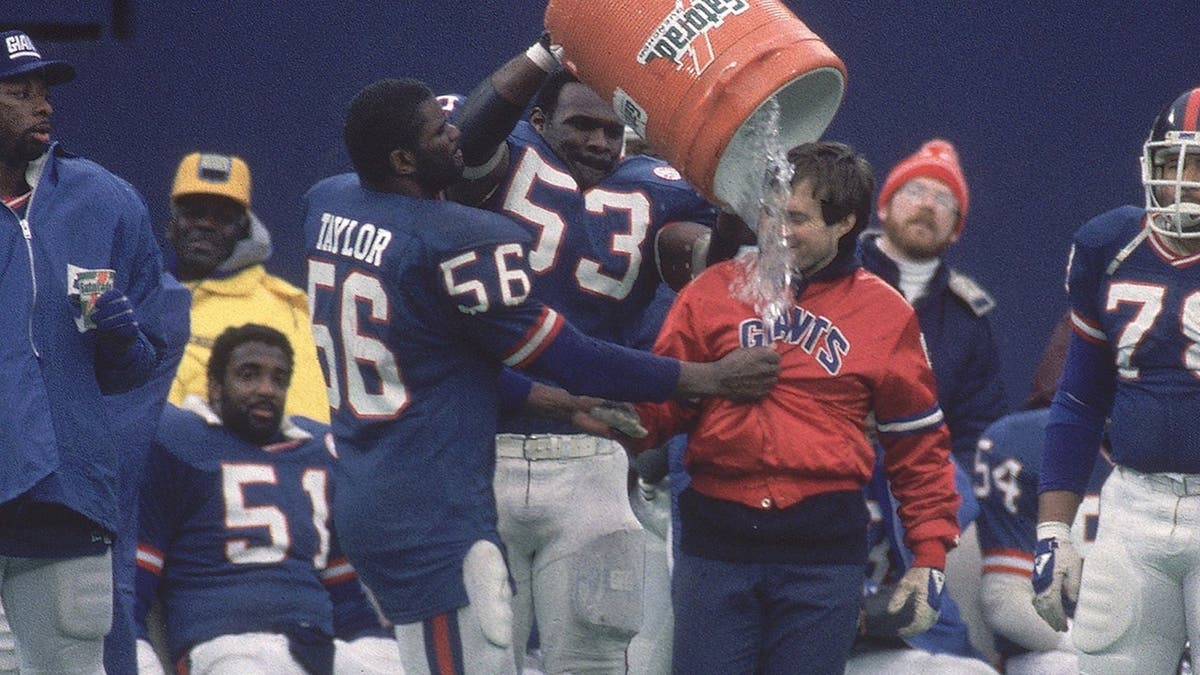 Lawrence Taylor and Bill Belichick celebrating with h2o bucket during shot game