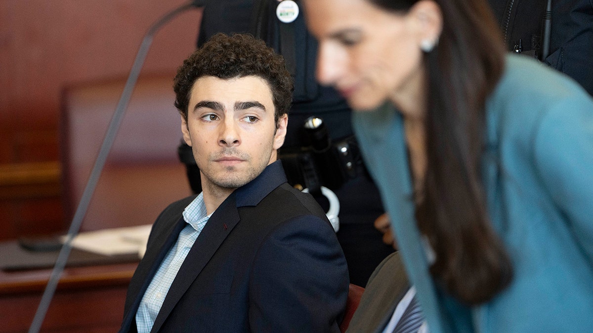Luigi Mangione appearing at an evidence suppression hearing in a courtroom.