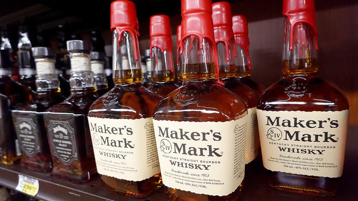 Bottle of Maker's Mark whisky sit on a shelf.