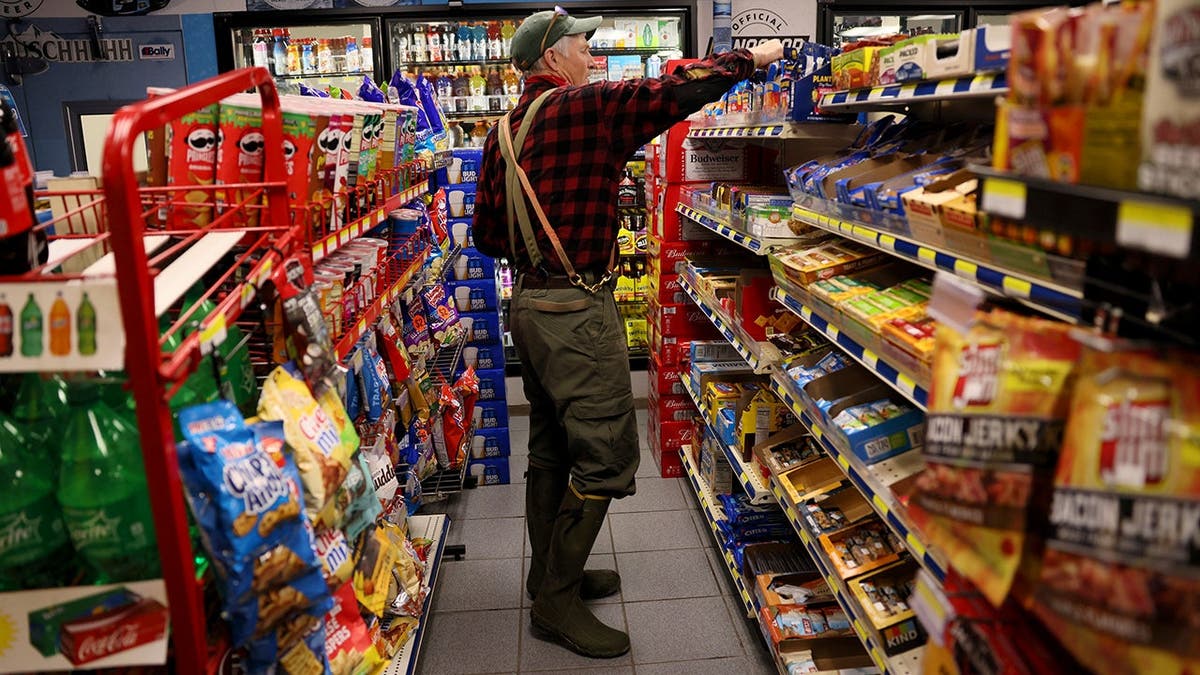 A man chooses snacks at a gas station.