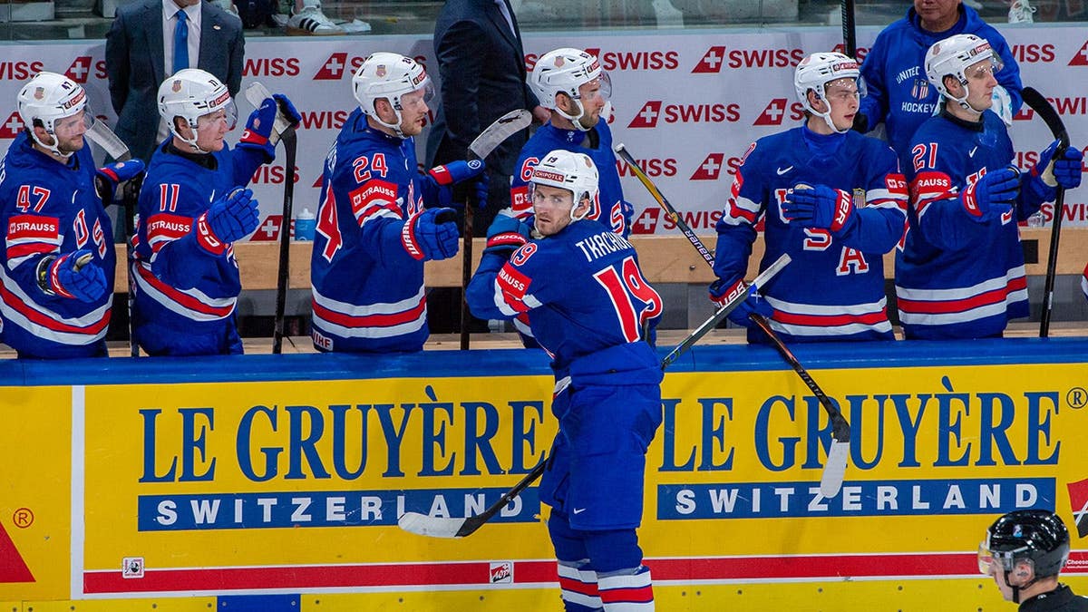 Matthew Tkachuk celebrating a goal with teammates on ice rink.