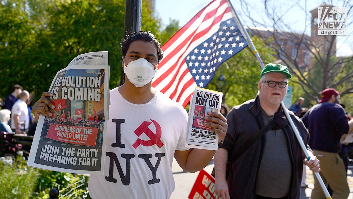 Unos simpatizantes del comunismo sostienen folletos y un periódico durante la marcha del Primero de Mayo en la ciudad de Nueva York, el viernes 1 de mayo de 2026.