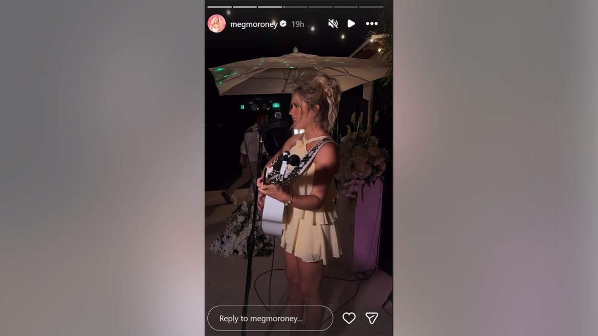 Megan Moloney plays the guitar in a yellow dress in May 2026.
