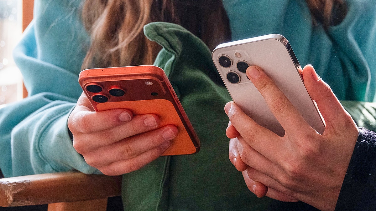 People on their iPhones.