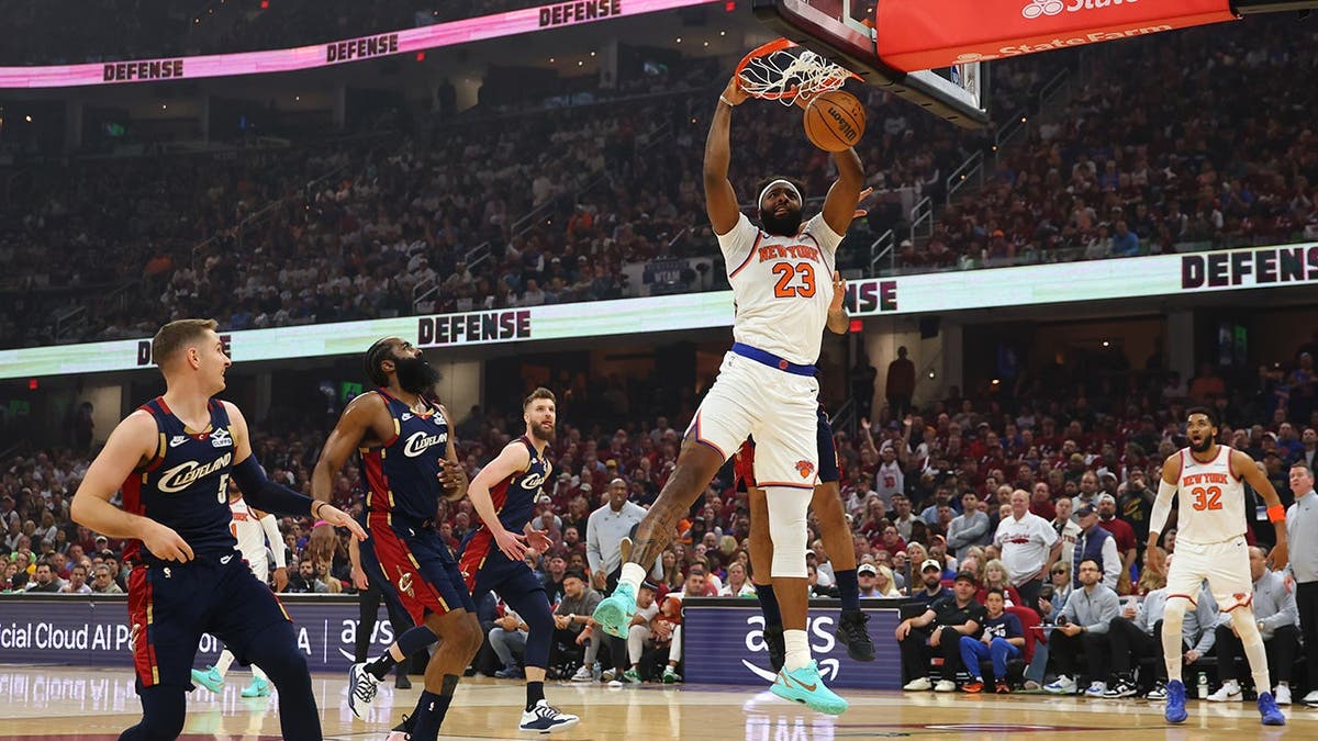 Mitchell Robinson of the New York Knicks dunks the basketball against Jaylon Tyson of the Cleveland Cavaliers.