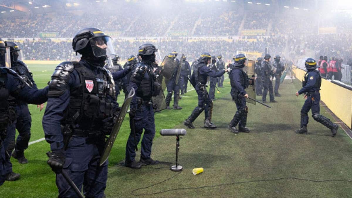 Riot police officers prevent Nantes fans from invading the field during the French L1 soccer match between FC Nantes and Toulouse FC at the Stade de la Beaujoire Louis Fonteneau in Nantes, western France, on May 17, 2026. (Photo by Sebastien Salom-Gomis/AFP via Getty Images)