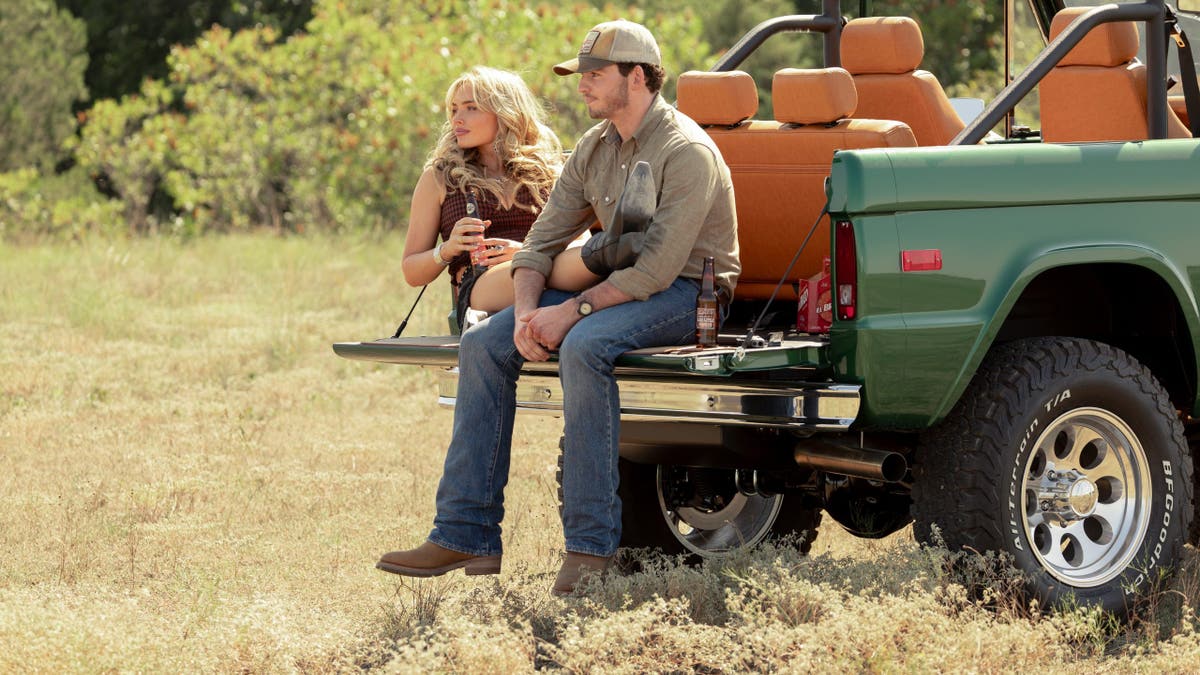 Natalie Alyn Lind as Oreana and Finn Little as Carter standing in Dutton Ranch