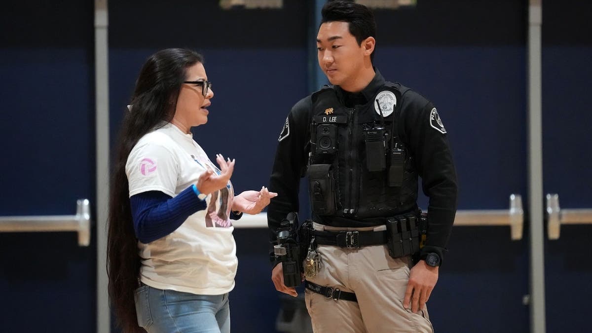Nereyda Hernandez talks to Placentia police officer Daniel Lee at the volleyball playoffs