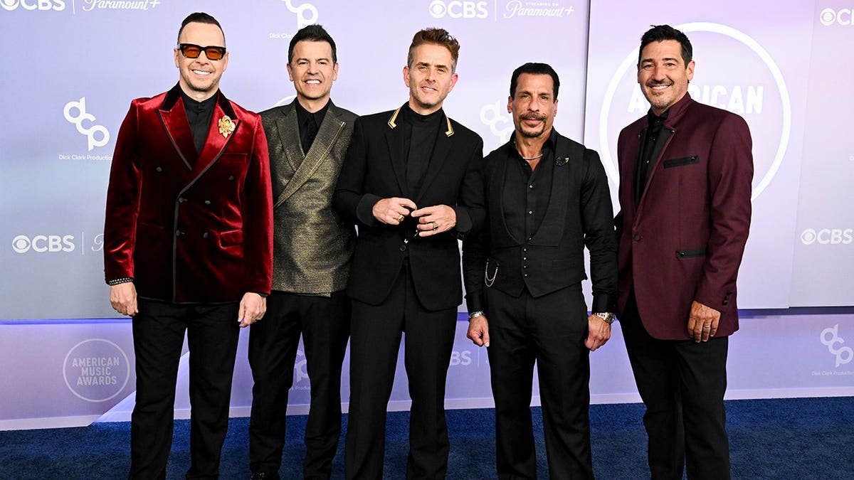 Donnie Wahlberg, Jordan Knight, Joey McIntyre, Danny Wood and Jonathan Knight standing together at the American Music Awards