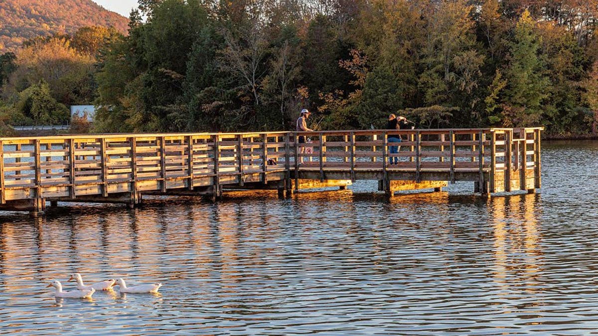 Homem e mulher pescando no cais do Lago Nickajack em Jasper, Tennessee.