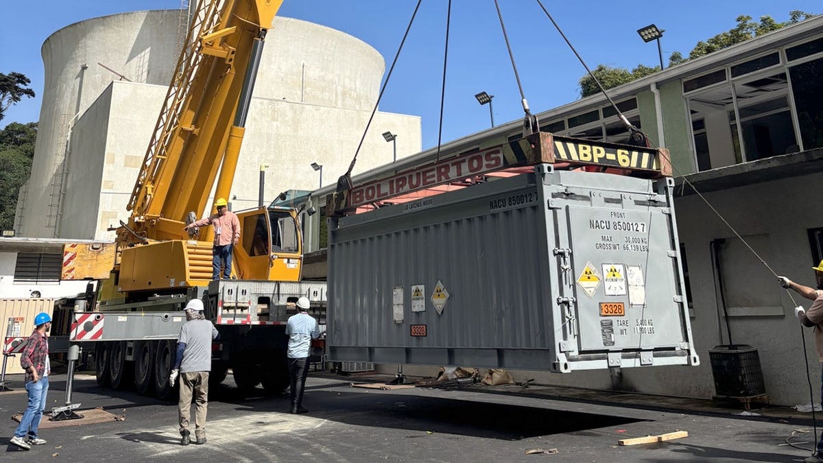 Large container suspended by crane