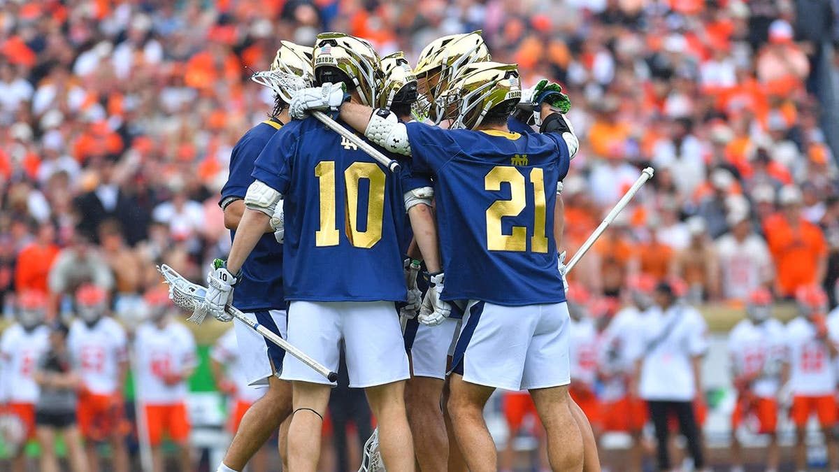 Notre Dame Fighting Irish lacrosse players celebrating a goal on the field