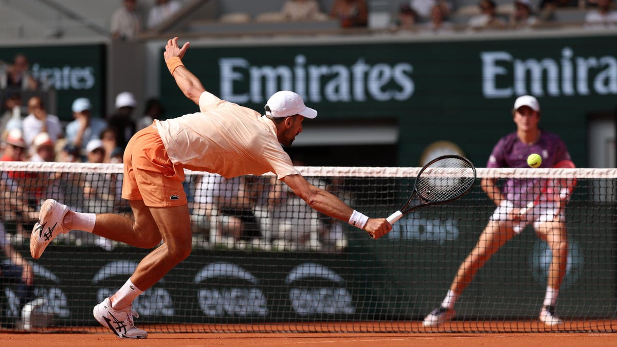 Novak Djokovic playing a volley at the net during a tennis match at the French Open in Paris