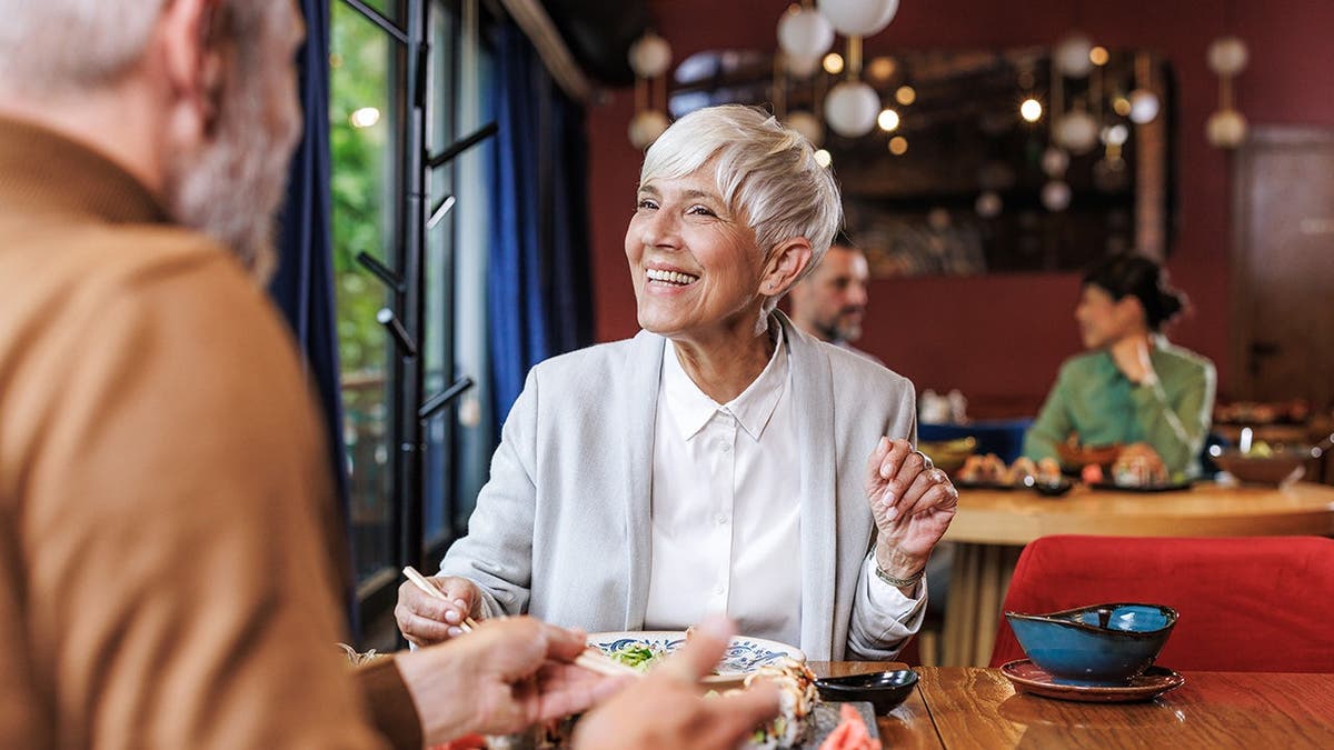 An older couple eats a meal together at a restaurant.