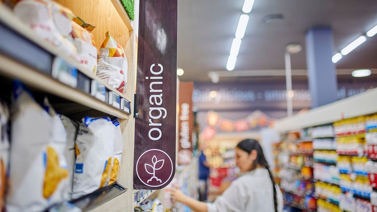Young woman selecting organic products in a supermarket aisle