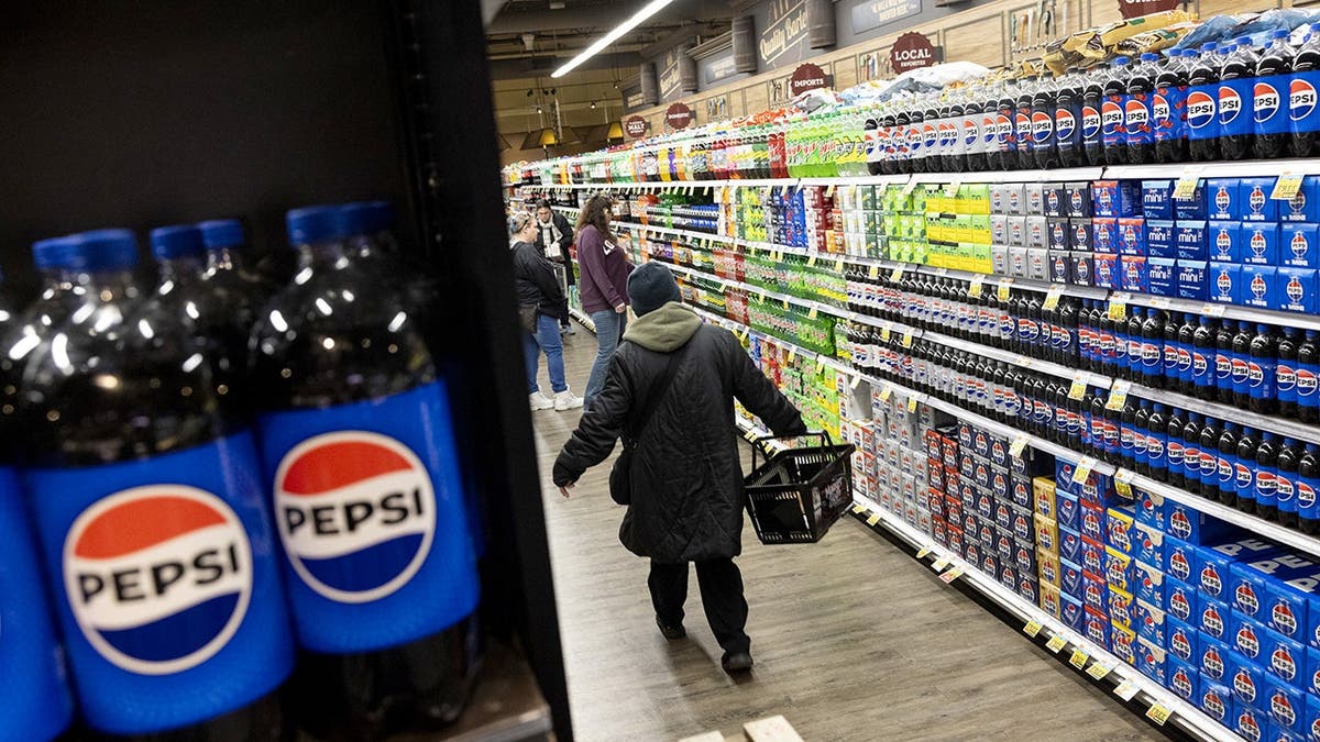 Bottles of Pepsi sit on a grocery-store shelf.