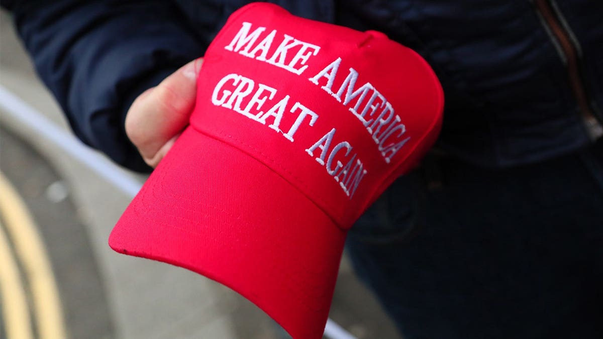 person-holds-MAGA-hat