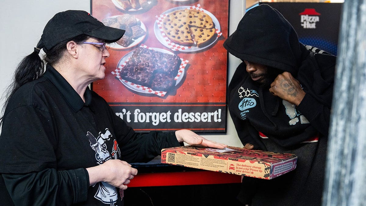 A Pizza Hut manager is talking to a delivery driver at a Pizza Hut restaurant in Nashville.