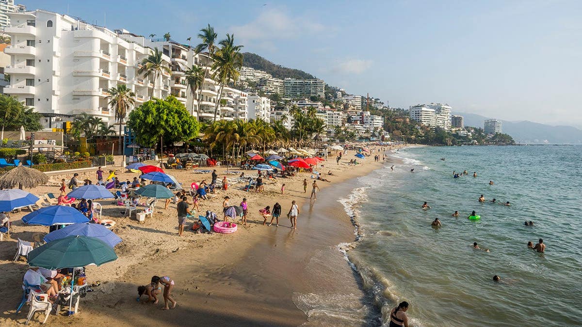 Beach scene at Playa de los Muertos in Puerto Vallarta with people on sand and in water