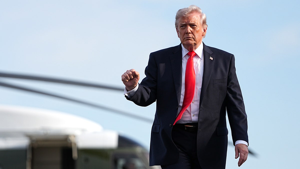 President Donald Trump walking from the Marine One helicopter toward Air Force One at an airport.