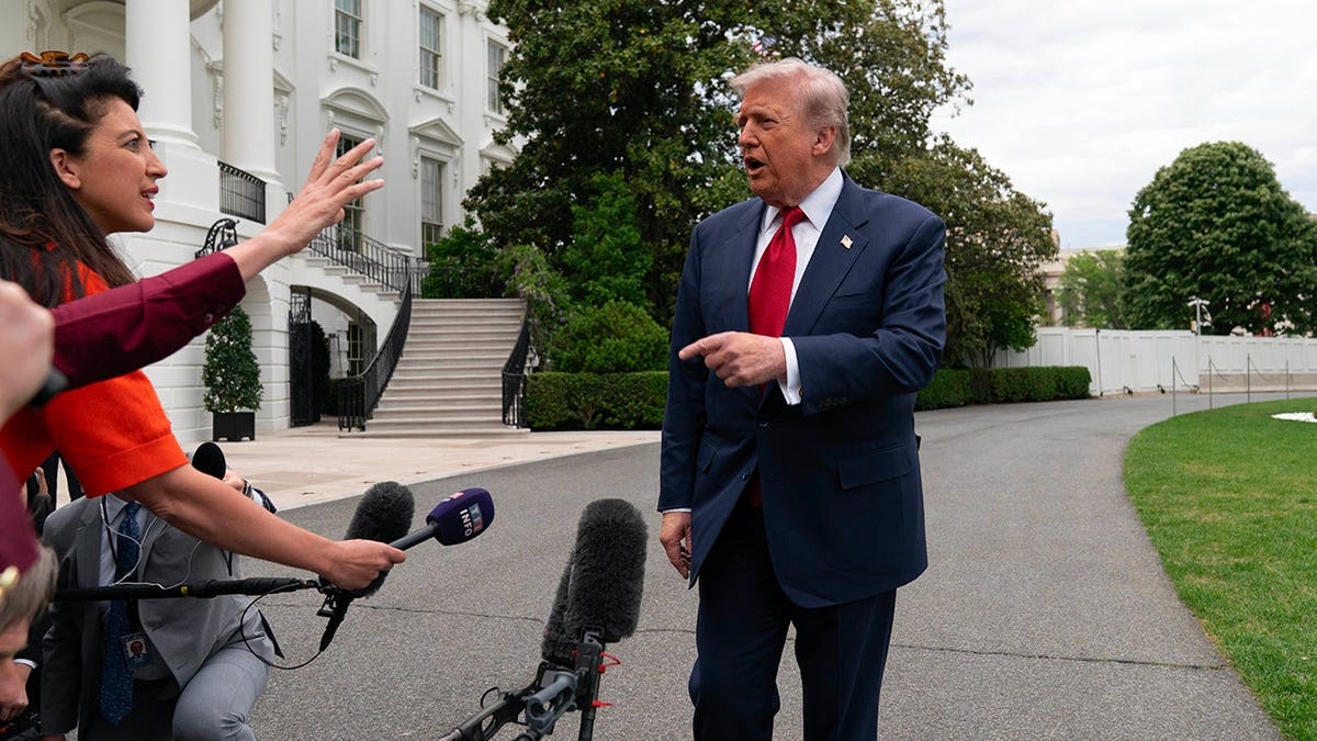 President Donald Trump speaking to reporters while walking on the South Lawn of the White House