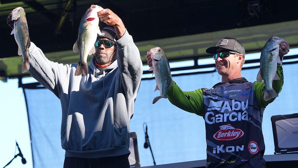O wide receiver da NFL Randy Moss e o pescador Hunter Shryock juntos em um evento de pesagem