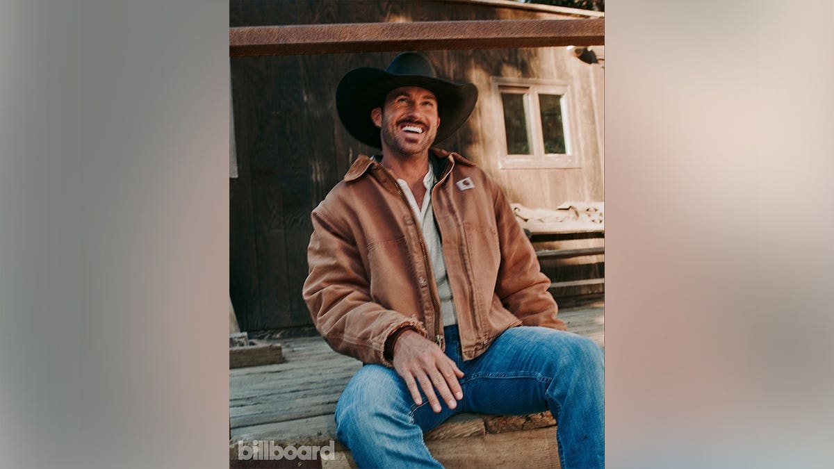 Riley Green in a brown jacket in photographs for Billboard in May 2026.
