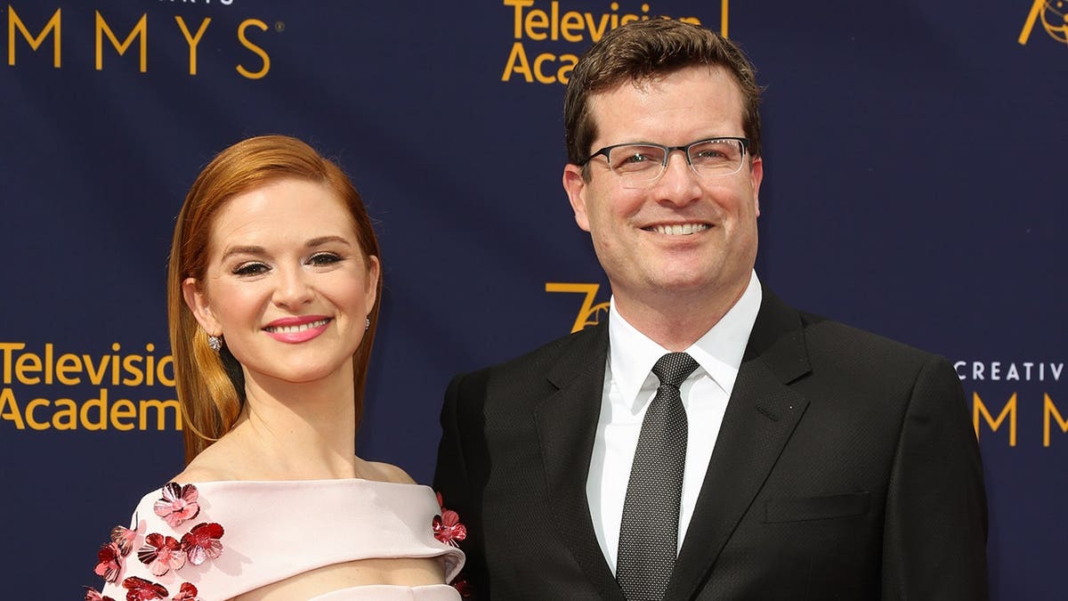 Actress Sarah Drew and her husband Peter Lanfer posing at Microsoft Theater in Los Angeles