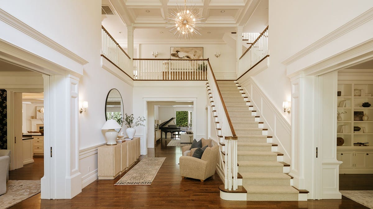 A spacious entryway with hardwood floors and a unique light fixture.