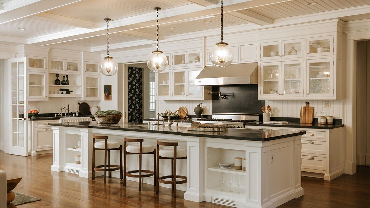 A kitchen featuring a large center island and white cabinets.