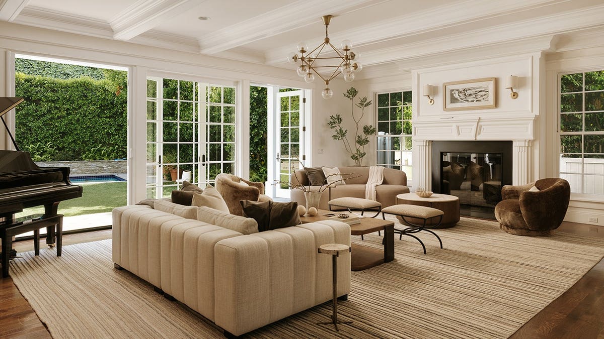 A sitting room with views of the backyard and a fireplace.