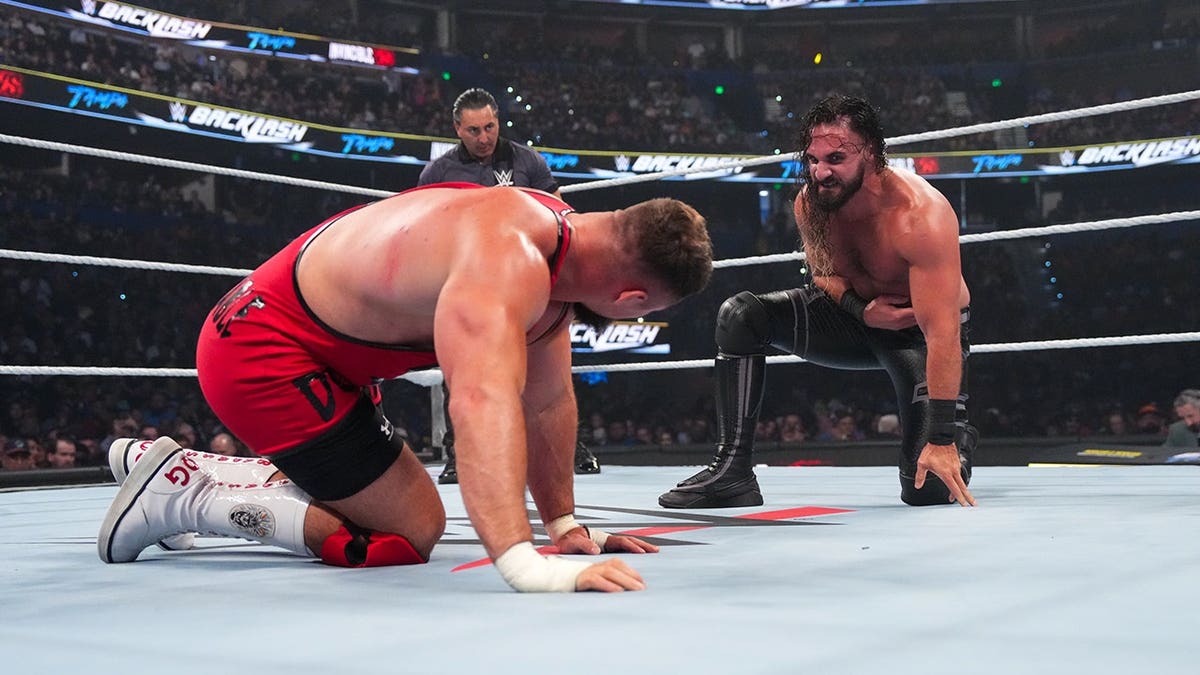 Seth Rollins and Bron Breakker face off in a wrestling ring at Benchmark International Arena