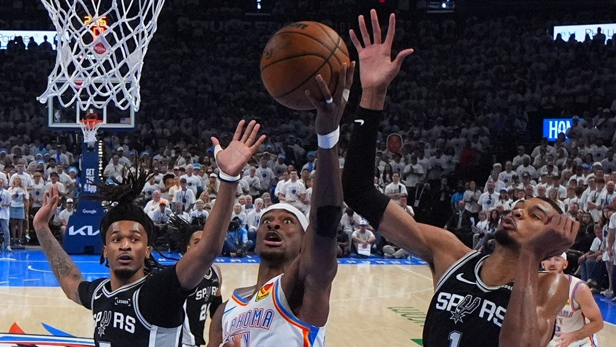 Oklahoma City Thunder guard Shai Gilgeous-Alexander shooting against San Antonio Spurs forward Victor Wembanyama