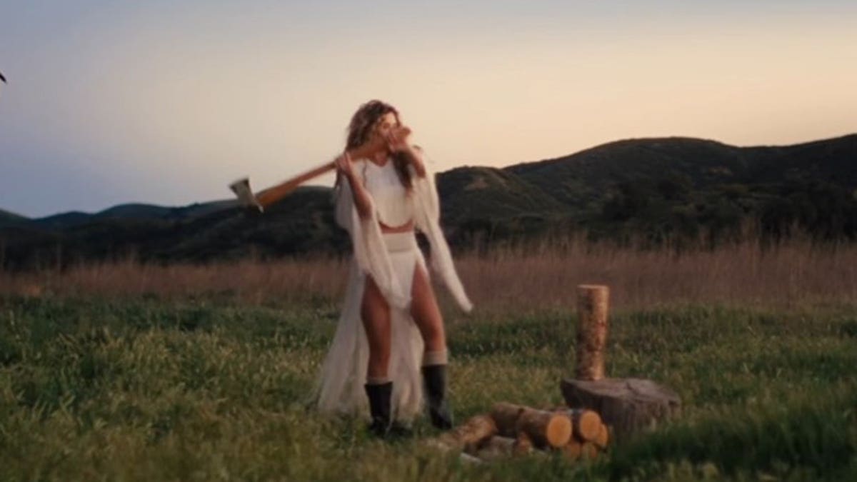 Shania Twain cortando lenha em uma postagem no Instagram provocando novas músicas.