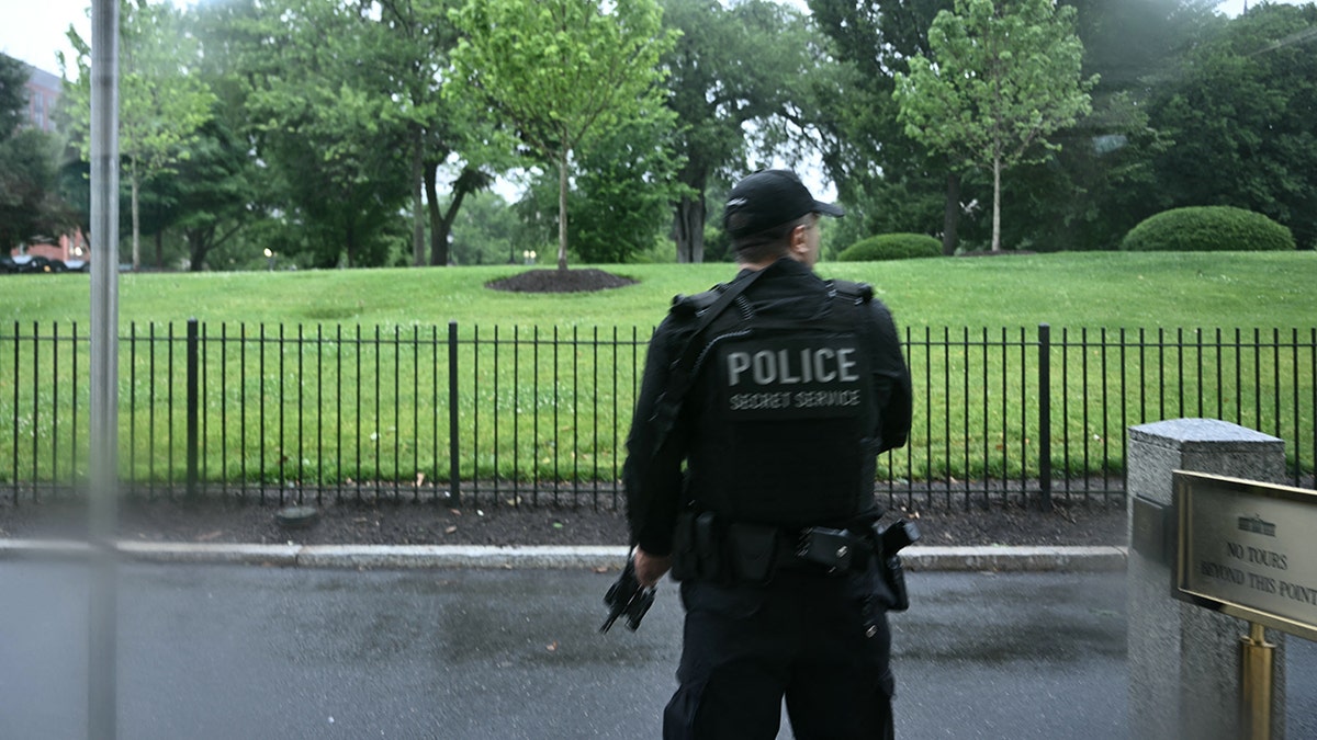 An armed Secret Service agent reacts at the White House