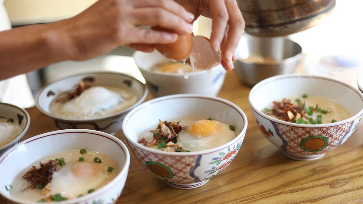 A woman making shrimp porridge in a kitchen