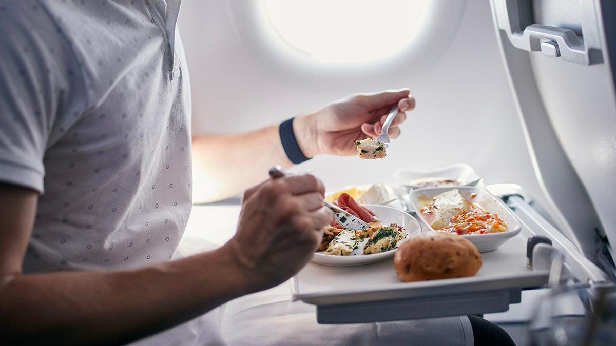 Passenger eating meal in business class on an airplane
