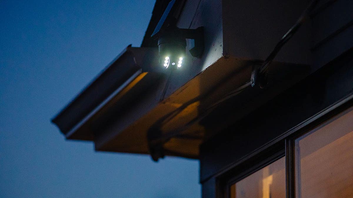 Close up of solar powered security light and camera on home exterior at twilight