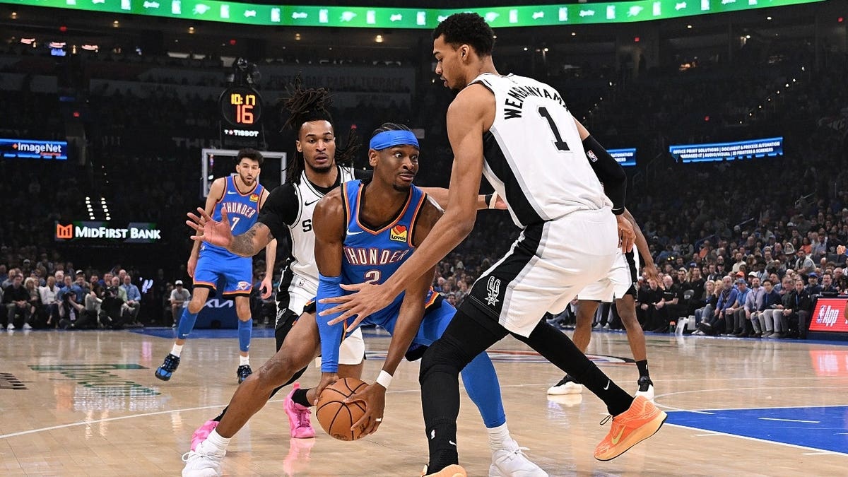 Thunder All-Star Shai Gilgeous-Alexander gets trapped by San Antonio Spurs big Victor Wembanyama and wing Stephon Castle at Paycom Center in Oklahoma City.